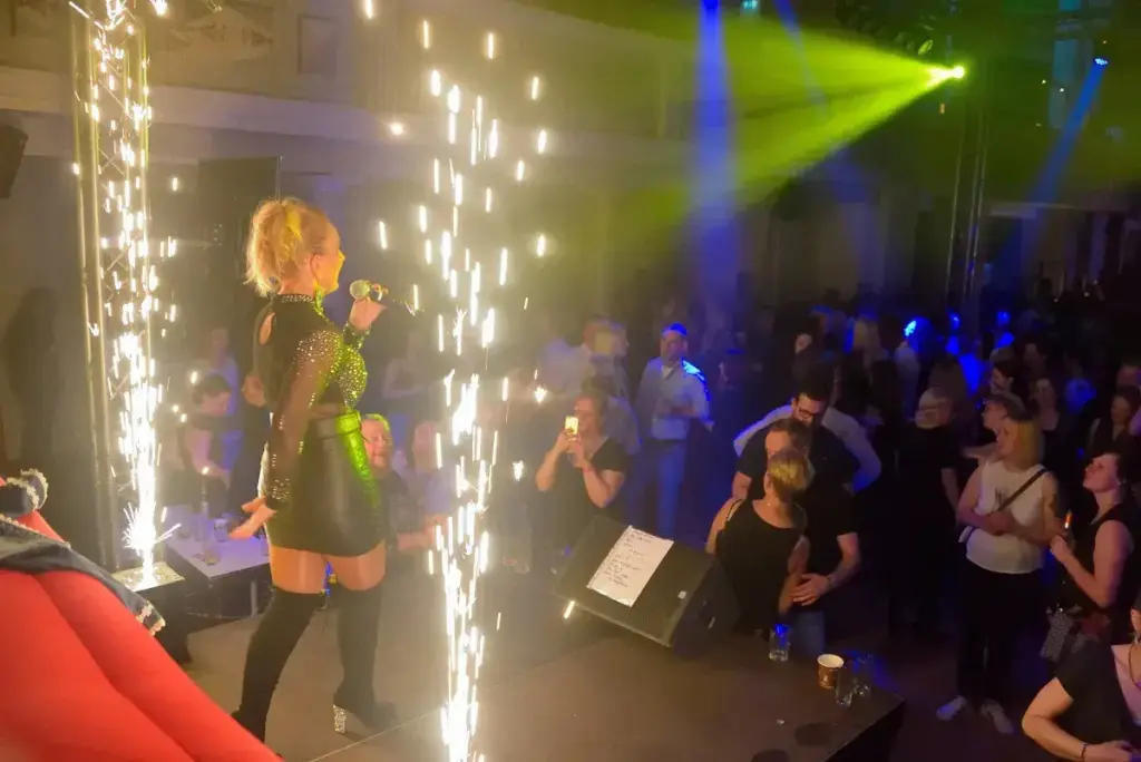 Corinna Anders singt auf der Bühne, davor eine jubelnde Menge im Funkenregen