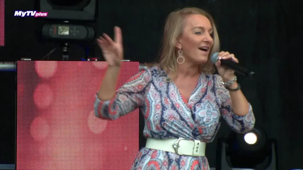 Corinna Anders singt auf der Bühne des Stadtfests, im Hintergrund helle Scheinwerfer